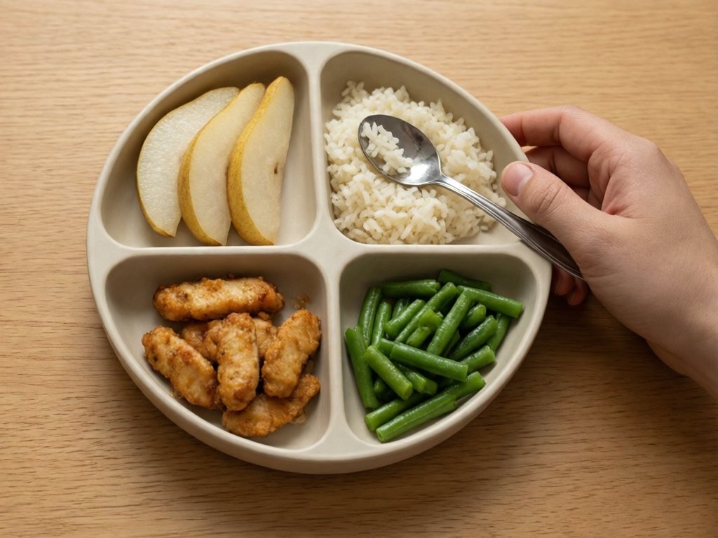 Divided plate with three thin pear slices beside rice, chicken strips and soft green beans